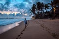 Girl walks on the evening tropical beach