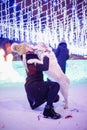 Girl walks with Labrador Retriever through forest, dog with deer horns. Christmas walk concept Royalty Free Stock Photo