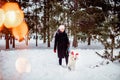 Girl walks with Labrador Retriever through forest, dog with deer horns. Christmas walk concept Royalty Free Stock Photo