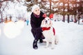 Girl walks with Labrador Retriever through forest, dog with deer horns. Christmas walk concept Royalty Free Stock Photo