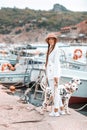 Girl walks with pet, adult Dalmatian on the waterfront with water transport. Royalty Free Stock Photo