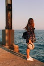 The girl walks on the pier in sunny weather and admires the sea scenery Royalty Free Stock Photo