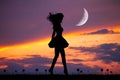 Girl walks at sunset with the waning moon