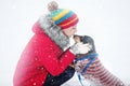 A girl in warm clothes and a hat walks in a snow-covered winter park