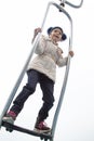 girl in warm clothes spins and balances on modern metal carousel outdoor in autumn