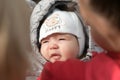 A girl in warm clothes on the street. A young and happy mother holds a baby in her arms, smiles and rejoices. Street in winter, Royalty Free Stock Photo