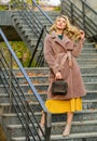 Girl warm coat stand urban stairs background. Create fall outfit to feel comfortable and pretty. Autumn outfit. Woman Royalty Free Stock Photo