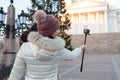 A girl in a warm hat, a winter day, shoots a video, a Christmas tree. Helsinki Royalty Free Stock Photo