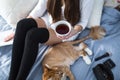 Girl with warm socks with a cup of tea, cat, close the book Royalty Free Stock Photo