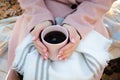 The girl warms her hands with a cup of coffee. Royalty Free Stock Photo