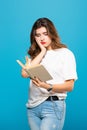 The girl was tired of reading books and leaned her head on her hand on a blue background. Incomprehensible digestible Royalty Free Stock Photo