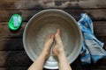 girl washes her feet in a basin of water on the wooden floor at home, foot care, wash feet at home, hygiene, swim Royalty Free Stock Photo