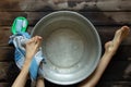 girl washes her feet in a basin of water on the wooden floor at home, foot care, wash feet at home, hygiene, swim Royalty Free Stock Photo