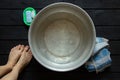 girl washes her feet in a basin of water on the wooden floor at home, foot care, wash feet at home, hygiene, swim Royalty Free Stock Photo