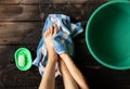 Girl washes her feet in a green bowl on the wooden floor of the house, foot care