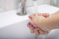 Girl washes her hands with soap in the bathroom. Hand disinfection.