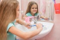 The girl washes a toothbrush under the tap Royalty Free Stock Photo