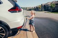 Girl washing car on driveway in front house on sunny summer day Royalty Free Stock Photo