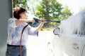 Girl washing a car in a self-service car wash station Royalty Free Stock Photo