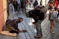 A girl watches a guy chatting with a beggar. Migrant begs on the street of a European