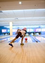 Girl watches intently at bowling ball rolls