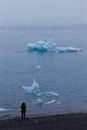 Girl watching bizarre ice floes of Iceberg lagoon jokulsarlon on the south of Iceland Royalty Free Stock Photo