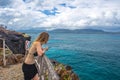 Girl watching the sea from the high cliff