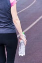 Girl with a water sleeve in her hands on the open sports arena