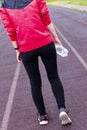 Girl with a water sleeve in her hands on the open sports arena