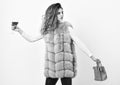 Girl wear fashion fur vest while posing with bag. Luxury store concept. Lady likes shopping. Elite fashion clothes