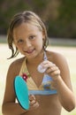 Girl (7-9) wearing bikini holding table tennis paddle and ball portrait.