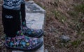 Girl wearing black rubber boots with pink designs