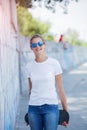 Girl wearing blank white t-shirt, jeans posing against rough street wall Royalty Free Stock Photo