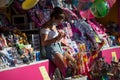 girl wearing a blue jeans short waiting in stand at the fun fair