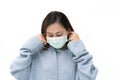 Girl wearing blue winter coat and mask againt flu and covid-19,corona virus by putting two ear hook and checking up