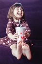 Girl wearing dress with hearts sitting on couch Royalty Free Stock Photo