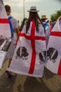 A girl wearing a flag of Sardinia in a park full of people