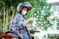 Girl wearing helmet and mask with thumbs up on motorbike Royalty Free Stock Photo