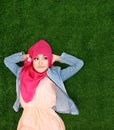 Girl wearing hijab lying on grass looking up to copyspace Royalty Free Stock Photo