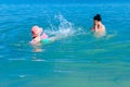 Girl is wearing inflatable armbands, learning to swim in the sea Royalty Free Stock Photo