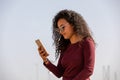 Young And Fashionable Mulatto Girl Using Smartphone