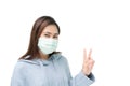 Girl wearing blue winter coat and mask againt flu and covid-19,corona virus, put up two fingers