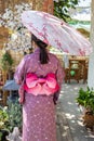 The girl is wearing a pink traditional yukata, which is the national dress of Japan