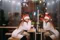 Girl wearing Santa Claus hat sitting in coffee shop Royalty Free Stock Photo