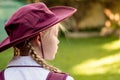 A girl wearing school uniform, white shirt, maroon backpack and a hat Back to school. Return to classrooms after COVID-19 outbreak