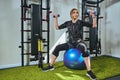 Girl wearing in sensors and belts, fastens with velcro practicing EMS fitness in gym, building up muscles with dumbbells Royalty Free Stock Photo