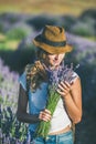 Girl wearing straw hat with bouquet of lavender flowers Royalty Free Stock Photo