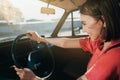 Girl wearing stylish outfit sitting behind the wheel in the driver& x27;s seat Royalty Free Stock Photo