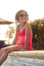 Girl Wearing Sunglasses Having Fun Sitting On Edge Of Swimming Pool On Summer Vacation Royalty Free Stock Photo