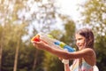 Girl Wearing Swimming Costume Having Fun Using Water Pistol For Water Fight In Summer Garden Royalty Free Stock Photo